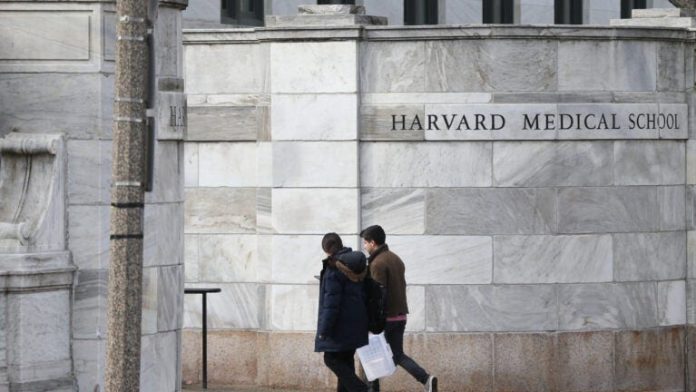 Dua orang berjalan di area Harvard Medical School, Amerika Serikat.