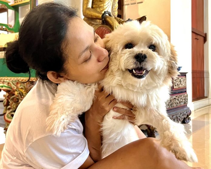 Ria tengah berpose bersama Kung Pau, anjing kecil yang ia temukan di jalanan tahun 2021 lalu (Foto: Elitha Evinora Br Tarigan/ THE EDITOR)