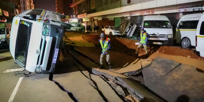 Jalan Lilian Ngoyi di Kota Johannesburg, Afrika Selatan, yang terbelah akibat ledakan pipa gas diperiksa oleh polisi.