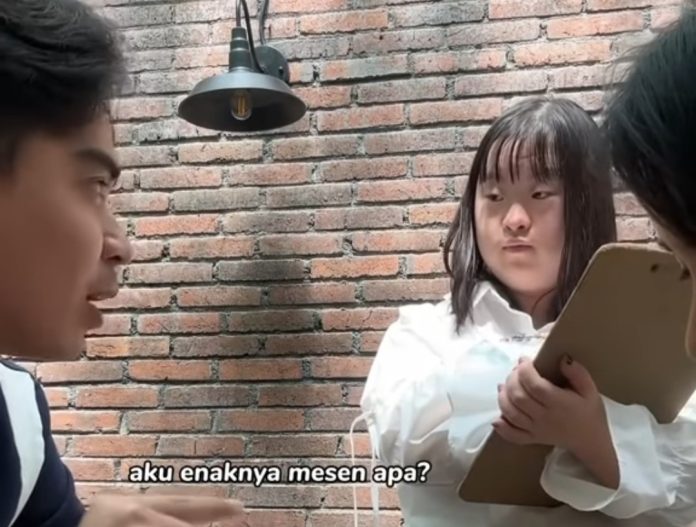 Momen ketika TikToker Arvhie Hanafi dilayani pelayan wanita berkebutuhan khusus di restoran Onni House, Surabaya, Jawa Timur.