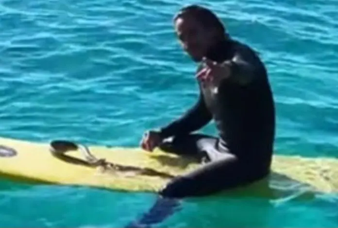 Higor Fiuza bersama ular pitonnya, Shiva, berselancar di perairan Gold Coast, Australia.
