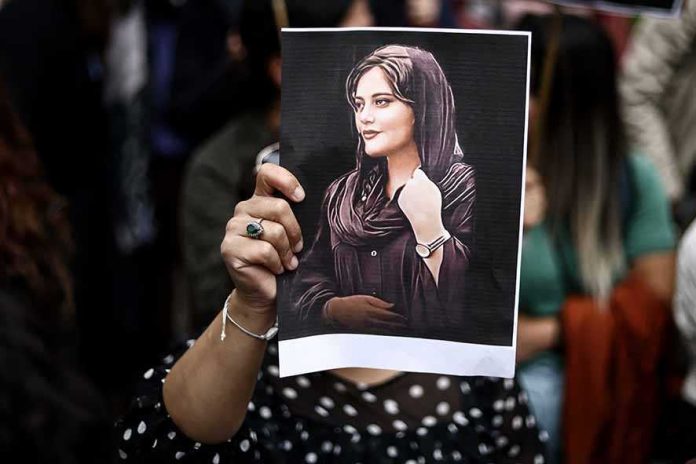 Seorang demonstran memegang potret mendiang Mahsa Amini dalam aksi unjuk rasa di depan Kedutaan Besar Iran di Belgia. (Foto: Kenzo Tribouillard/AFP)