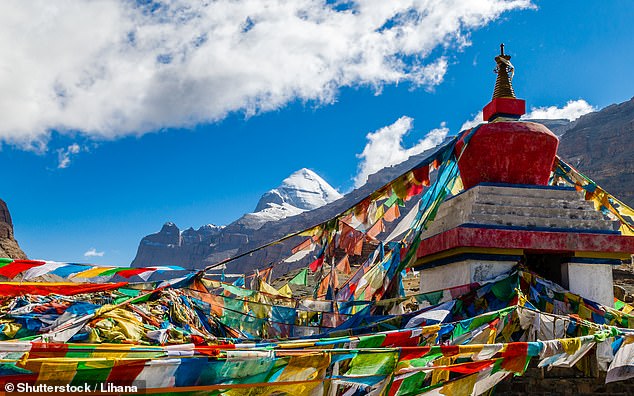 Bendera warna-warni berkibar tertiup angin dengan latar belakang sisi selatan Gunung Kailash (Foto: Daily Mail/ THE EDITOR)