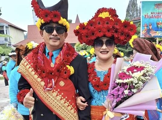 Parade participants show off a typical Karo bridal outfit decorated with flowers during the 2024 Taneh Karo Flower and Fruit Festival. (Photo: Ardhy Tarigan/THE EDITOR)