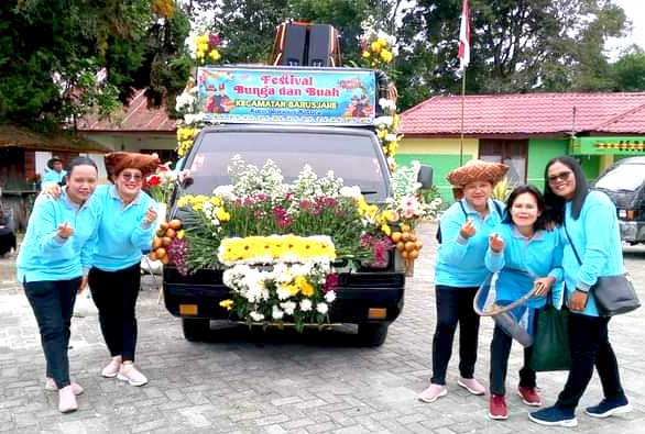 Peserta berpose di salah satu mobil hias yang ikut berpartisipasi di Festival Bunga dan Buah Taneh Karo tahun 2024 (Foto: Ardhy Tarigan/ THE EDITOR)