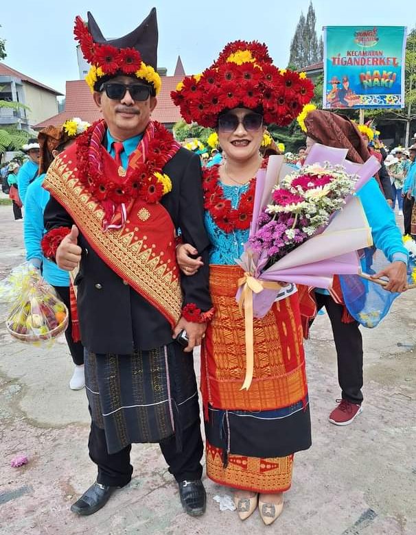 Peserta pawai yang tengah memamerkan pakaian pengantin khas Suku Karo yang dihiasi bunga dałam acara Festival Bunga dan Buah Taneh Karo tahun 2024 (Foto: Ardhy Tarigan/ THE EDITOR)