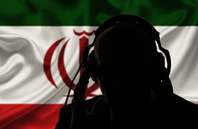 The silhouette of a man, seen over the flag of the Islamic Republic of Iran (illustrative) (PHOTO: SHUTTERSTOCK/THE JERUSALEM POST)
