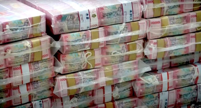 Sebagian uang dalam bentuk mata uang rupiah yang terlihat bertumpuk-tumpuk di ruang konferensi pers Kejaksaan Agung tentang skandal korupsi ekspor minyak goreng pada Kamis, 17 Juni 2025 (FOTO: Tangkapan Layar Youtube Kejaksaan Agung/THE EDITOR)