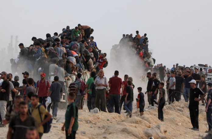 Palestinians climb onto trucks carrying aid supplies that entered Gaza through Israel, in Beit Lahia, in the northern Gaza Strip July 29, 2025 (PHOTO: REUTERS/DAWOUD ABU ALKAS/The Jerusalem Post/THE EDITOR)