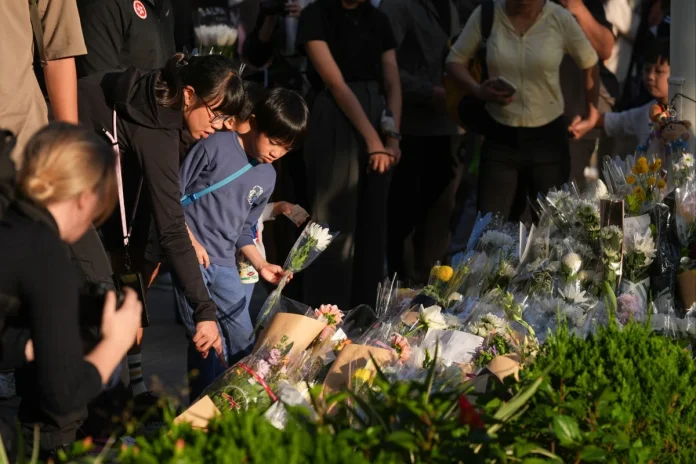 People leave flowers as Hongkongers mourn the fire victims. (Photo: Eugene Lee/ South China Morning Post/The Editor)