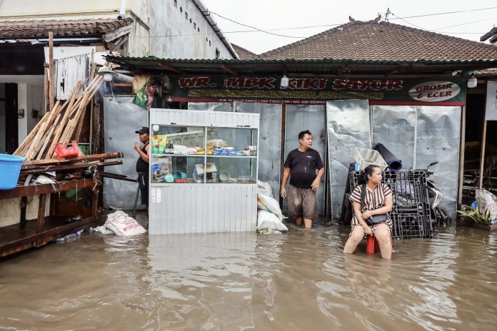 People try to clean up their shop after severe flooding in Denpasar, Bali, in September. (Photo: Anadolu/Getty/The Guardian/The Editor)