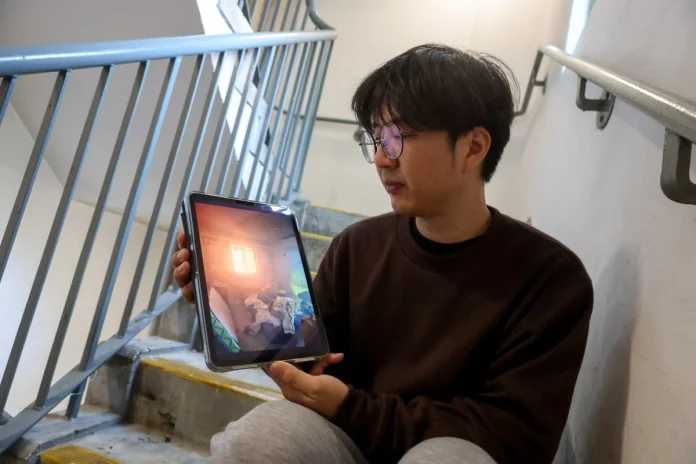 William Li shows a photo taken from inside his flat during the fire on Wednesday. (Photo: Edmond So/South China Morning Post /The Editor)