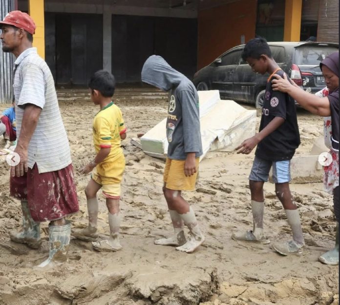 Kaki korban banjir terlihat tengah memakai sepatu boot alami karena lumpur yang harus mereka lalui saat berjalan cukup dalam (Foto: Instagram @vaticannewspt)