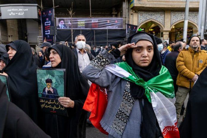 A woman gestures during a mass funeral held for over 100 members of the security forces whom authorities said were killed during recent nationwide protests, on January 14, 2026 outside Tehran University in Tehran, Iran (Stringer/Getty Images/The Al Jazeera)
