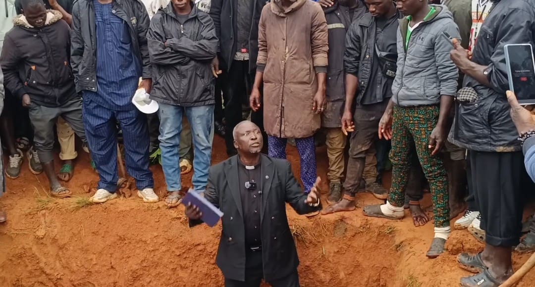 Aktivis hak asasi manusia, Pendeta Ezekiel Dachomo, menangis pilu saat berdiri di depan 21 korban serangan 22 Juni yang dibaringkan di dalam kuburan massal di Desa Kawel, wilayah Bokkos, Jos, Nigeria (Foto: Masara Kim/TruthNigeria).