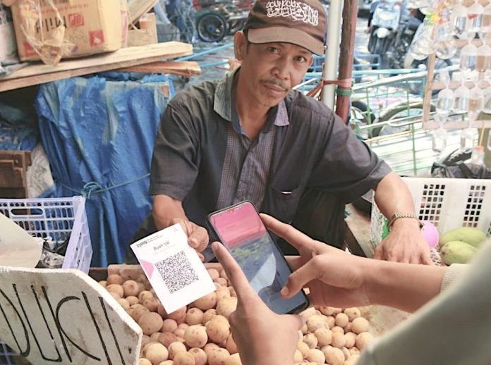 Pedagang di Samarinda yang telah menggunakan QRIS sejak tahun 2021 tengah melayani pembayaran dengan sistem digital pada pelanggannya (Foto: Kaltim Aktual/Dian Adi Pranowo).