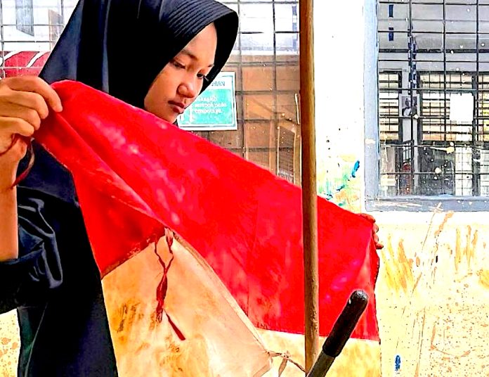 Media Vatikan mengunggah foto seorang wanita korban banjir terlihat tengah menyelamatkan bendera kebangsaan Indonesia yang berwarna merah dan putih dari banjir (Foto: Instagram @vaticannewspt)