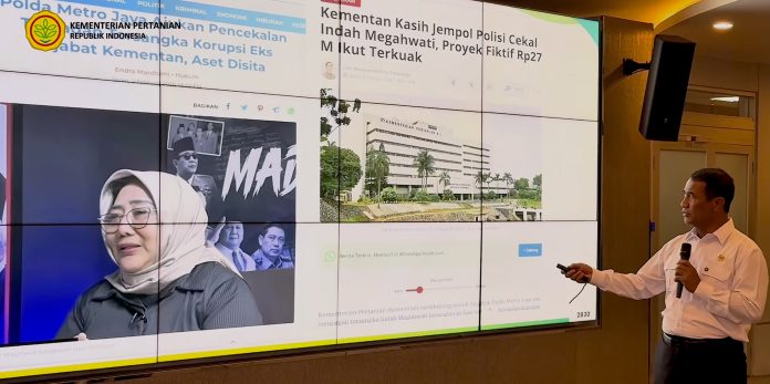 Menteri Pertanian Andi Amran Sulaiman (kanan, baju putih) menunjukkan foto pejabat Kementan bernama Indah Megawati (kiri) yang kedapatan melakukan korupsi dengan total mencapai Rp26 miliar di hadapan wartawan dalam acara konferensi pers di Gedung Kantor Pusat Kementerian Pertanian (Kementan), Ragunan, pada Kamis siang, 30 Juli 2026. (Foto: Hasil tangkapan layar YouTube dari akun resmi Kementerian Pertanian).